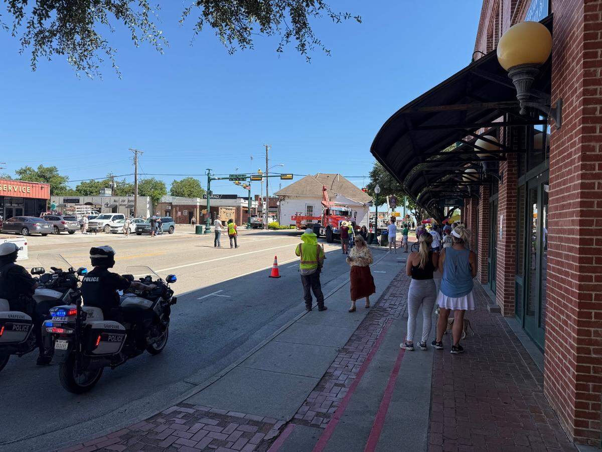 Residents of Grapevine gather along main street to catch a glace at the Winfrey house being moved.