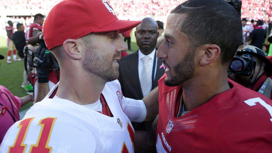 Then-Kansas City Chiefs quarterback Alex Smith, left, hugs then-San Francisco 49ers quarterback Colin Kaepernick after a game in 2014.