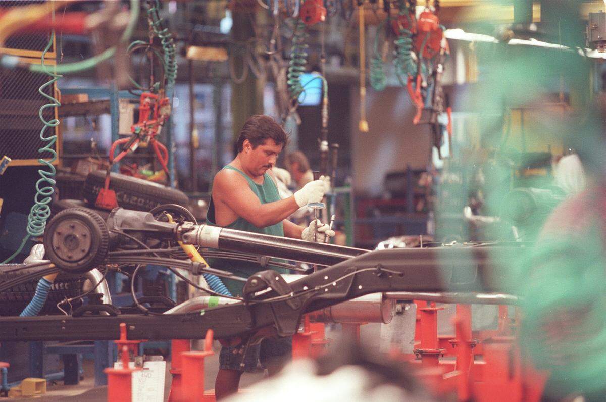 July 1997: A General Motors employee works on a truck frame as it goes along the assembly line at the Arlington plant.