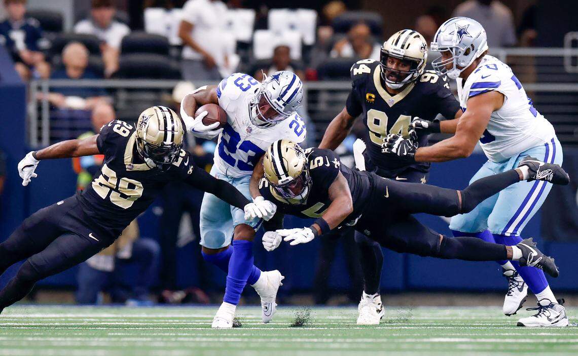 Dallas Cowboys running back Rico Dowdle (23) is blocked by New Orleans Saints cornerback Paulson Adebo (29) and strong safety Will Harris (5) on Sunday, Sept. 15, 2024, at AT&T Stadium in Arlington.
