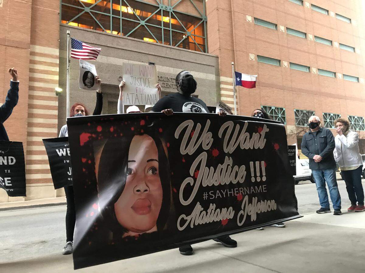 Kwame Osei (middle) holds up a banner for Atatiana Jefferson at a protest in March 2021 in downtown Fort Worth, Texas demanding a trial date for the officer who shot and killed Jefferson in October 2019. Osei is a leader in Enough is Enough Fort Worth, the group that organized the event.