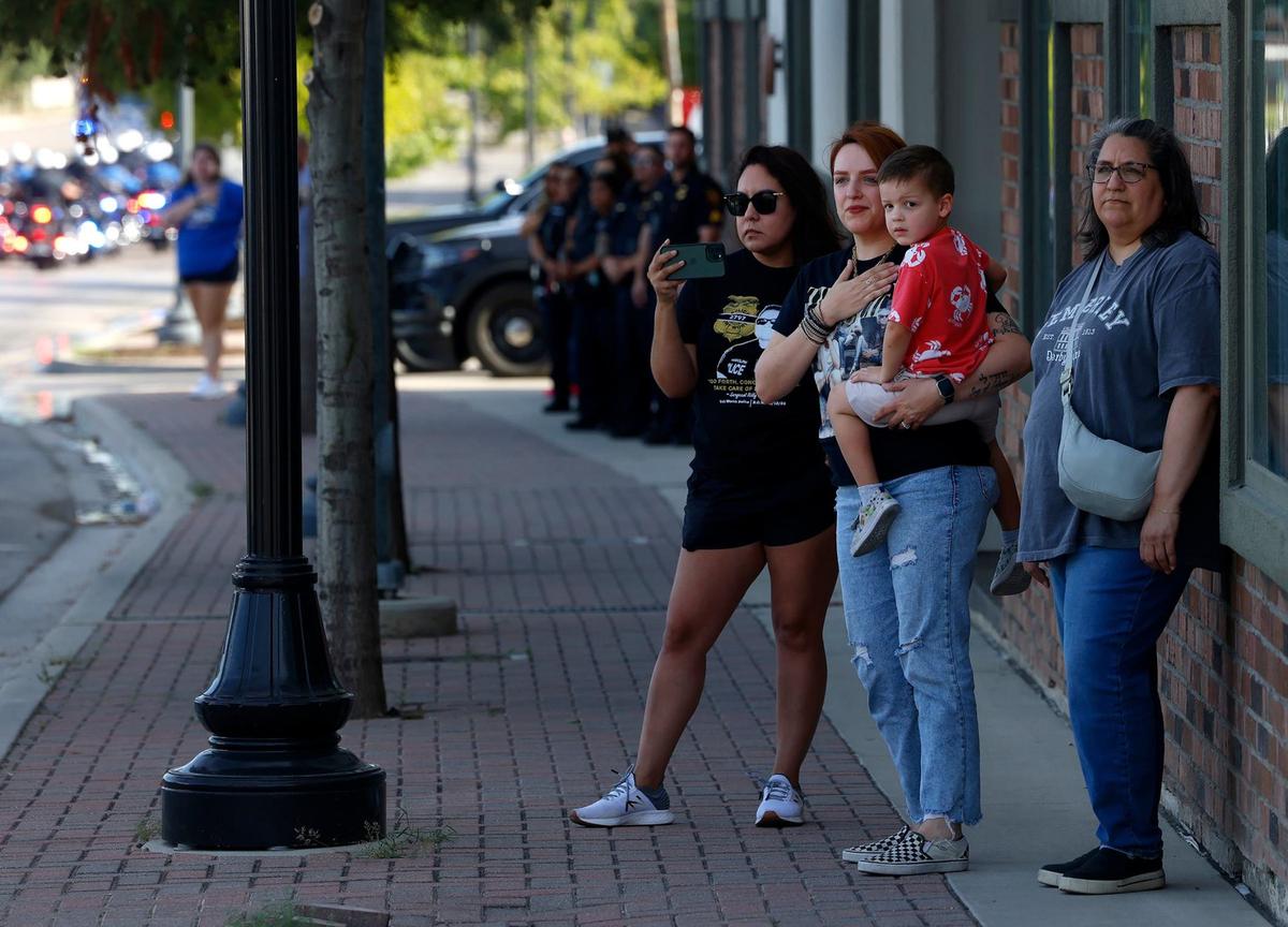 Community members watch the procession for fallen Fort Worth police officer Sgt. Billy Randolph on Saturday on Magnolia Street in Fort Worth.