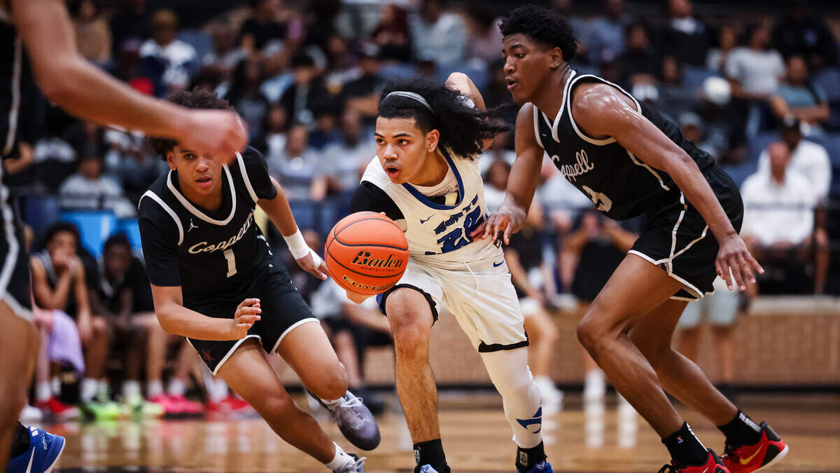 North Crowley guard Isaak Hayes (22) attempts to dribble past two Coppell defenders in a Class 6A Division I regional semifinal on Tuesday at Mansfield Timberview.