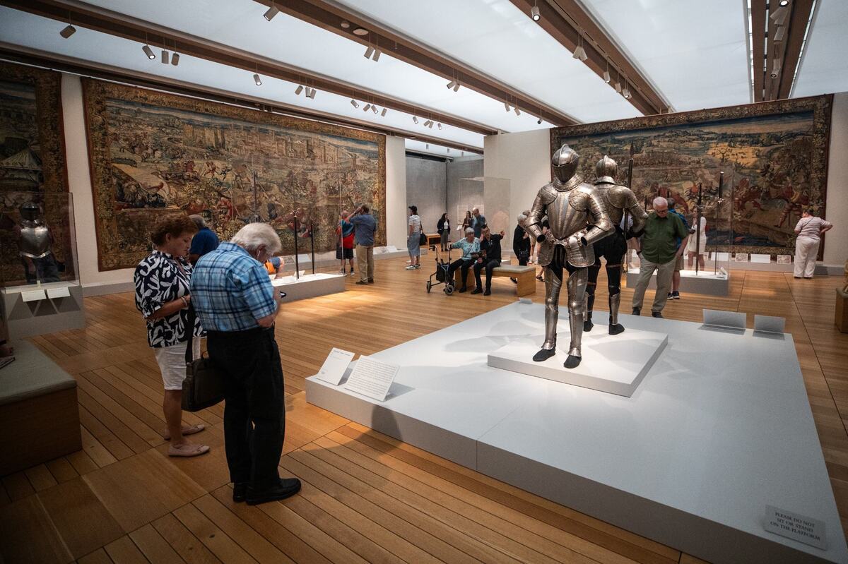 Attendees stand in front of a knight statue at the ‘Art and War in the Renaissance: The Battle of Pavia Tapestries’ exhibit on Friday, June 14, 2024, at the Kimbell Art Museum.