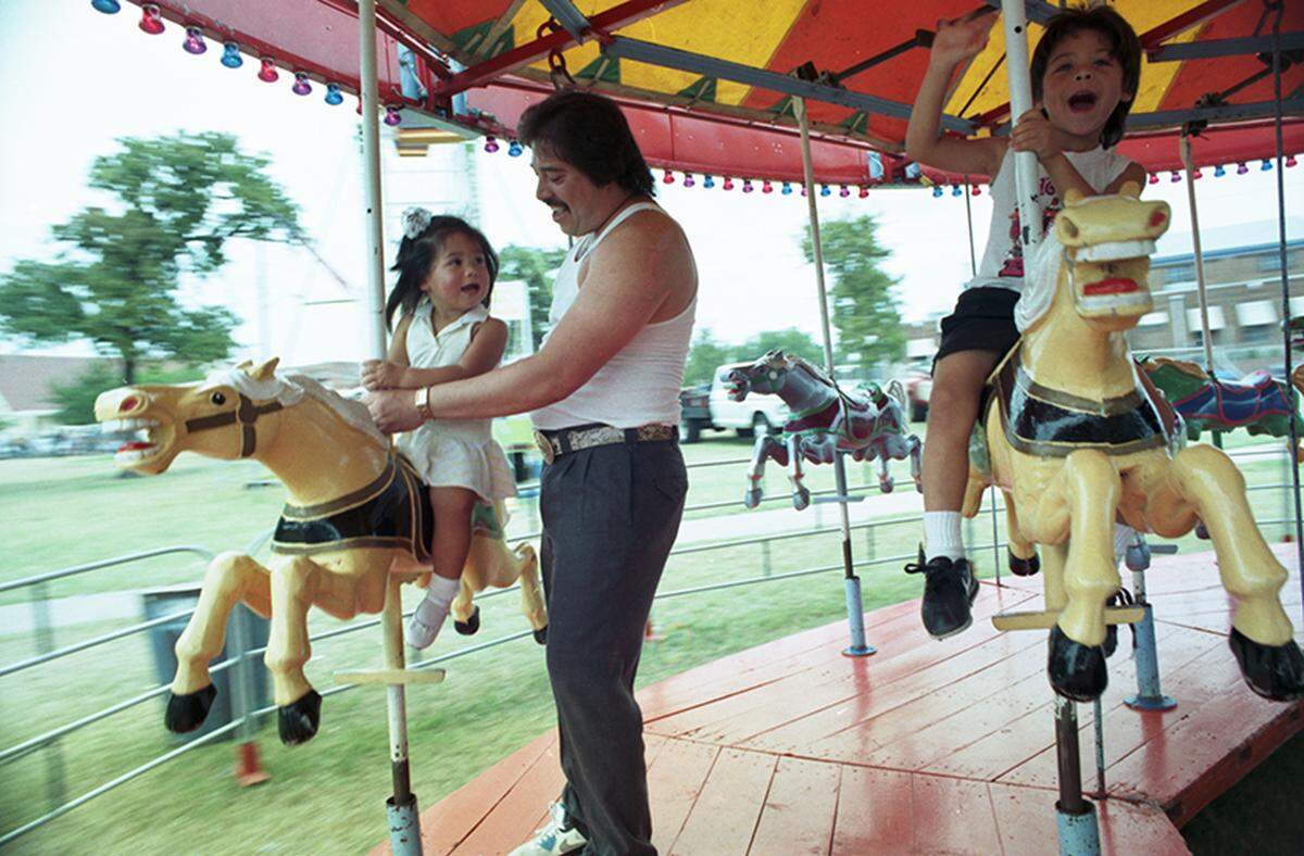 Sept. 17, 1990: Frank Diaz takes his children Ceci, left, and Frankie for a ride on the carousel at the 16 de Septiembre Fiesta at Marine Park in Fort Worth.