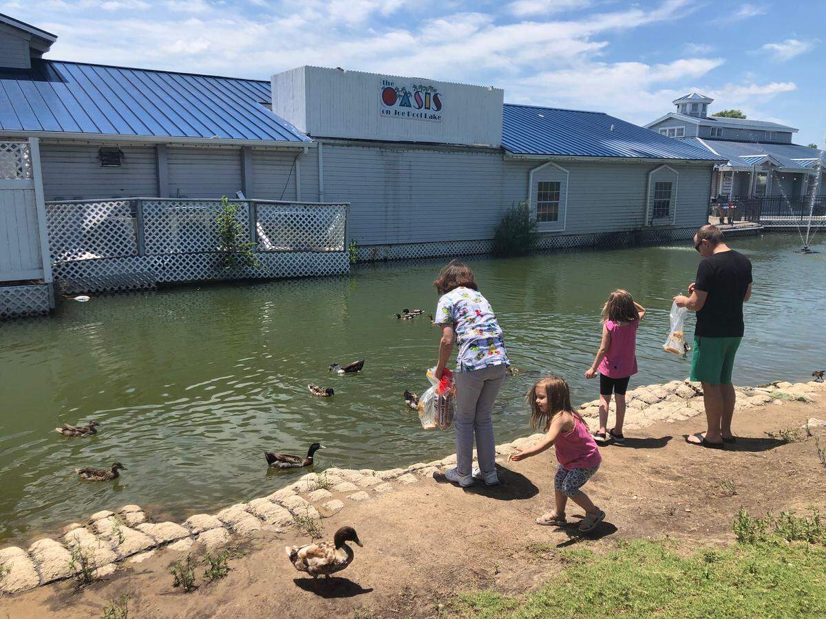 A family feeds ducks at the Oasis at Joe Pool Lake.