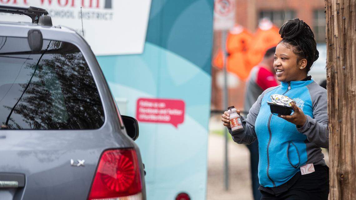 Cheyenne Harris delivers a meal for a child in the car March 16 at De Zavala Elementary School.