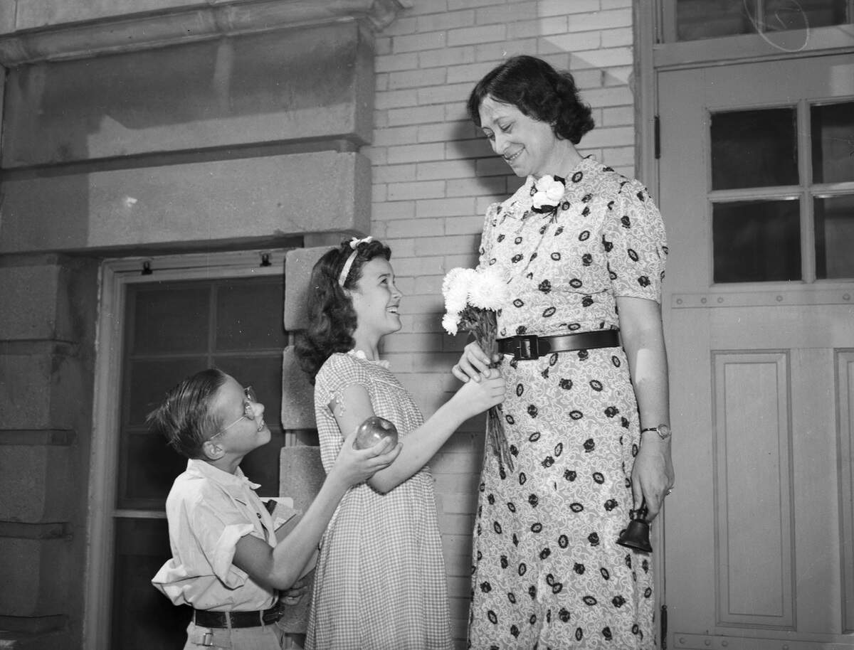 Sept. 4, 1940: The first day of school at Alexander Hogg Elementary is opening with a scene that is probably typical across Fort Worth. Left to right are, Donald Leach, Billie Ruth Valentine and Miss Beulah Johnson. Donald, 10, is trying the old-fashioned custom of bringing his new teacher a shiny red apple. Billie Ruth, 11, is trying a different approach. Her friendship offering is a bouquet of daisies.