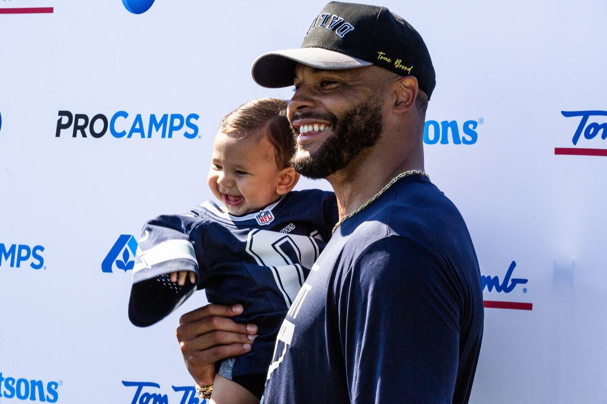 Dallas Cowboy quarterback Dak Prescott takes a photo with a baby during youth football pro camp on Tuesday July 9 at Carroll senior high school southlake practice field. Staff members had the opportunity to take photos with Prescott.