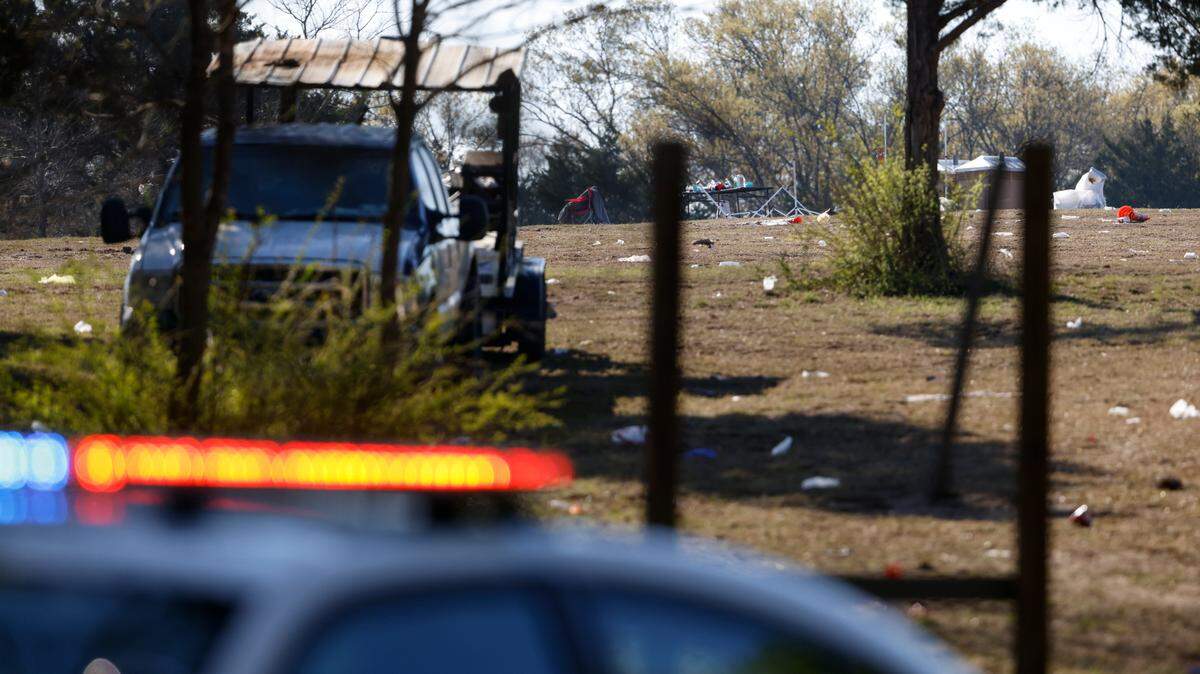 A police car sits in front of the scene, Sunday, April, 3, 2022, where a man was fatally shot and at least 16 other people were injured in connection to a shooting Saturday night at a concert in Dallas, Texas. (Rebecca Slezak/The Dallas Morning News via AP)