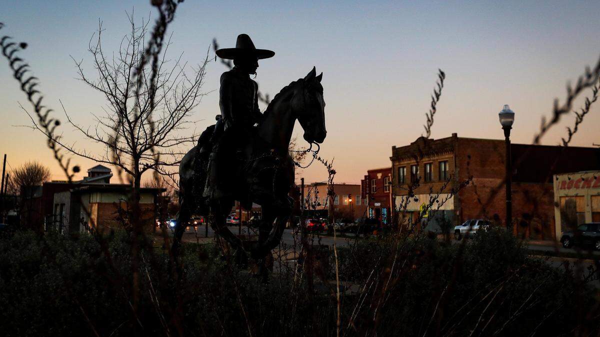 The sun sets on North Main Street in Fort Worth’s Northside community, where the “Vaquero de Fort Worth” statue stands at the plaza by Central Avenue.