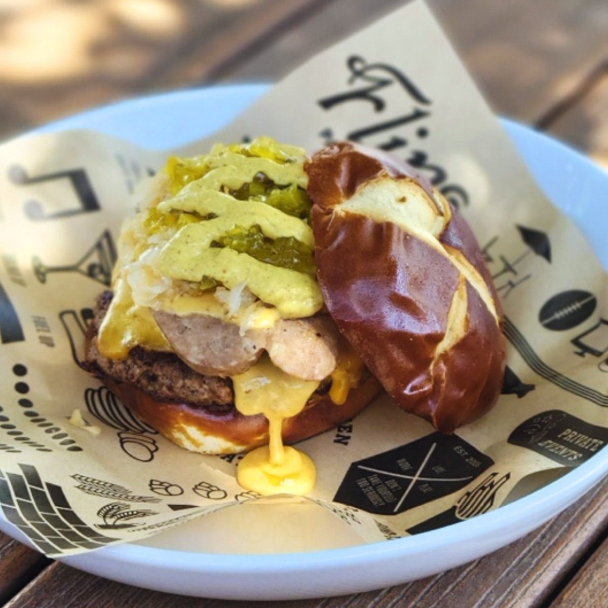 Flip’s October special: Beer Cheese Brat Burger, 50/50 patty topped with a beer-braised bratwurst, house-made beer cheese and piled high with German-style sauerkraut, sweet relish, and spicy mustard, all on a Pretzel Bun.
