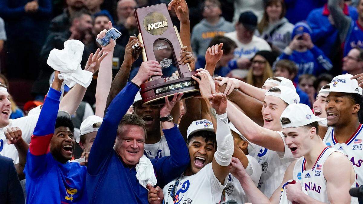Kansas head coach Bill Self and players hold up the winning trophy after beating Miami to advance to the Jayhawks’ 16th Final Four. No. 1 Kansas plays No. 2 Villanova at 5:09 p.m. Saturday in the first NCAA National Semifinal at the Superdome in New Orleans.