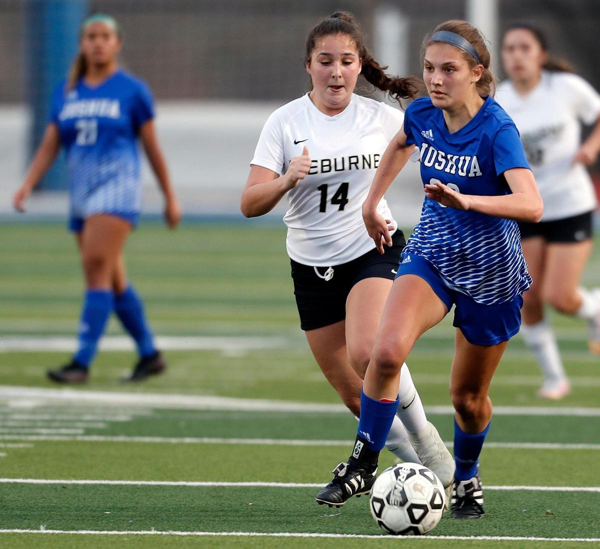 Joshua’s Trinity Grabeal (23) kicks the ball ahead of Cleburne’s Faith Renick (14) during a District 14-5A high school soccer game at Joshua High School in Joshua, Texas, Monday, March 08, 2021. The girls played to a scoreless game. (Special to the Star-Telegram Bob Booth)