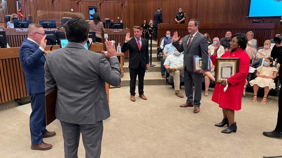 Michael Crain, center, is sworn in as the District 3 council member Tuesday, along with incumbent council members Carlos Flores, Cary Moon and Gyna Bivens.