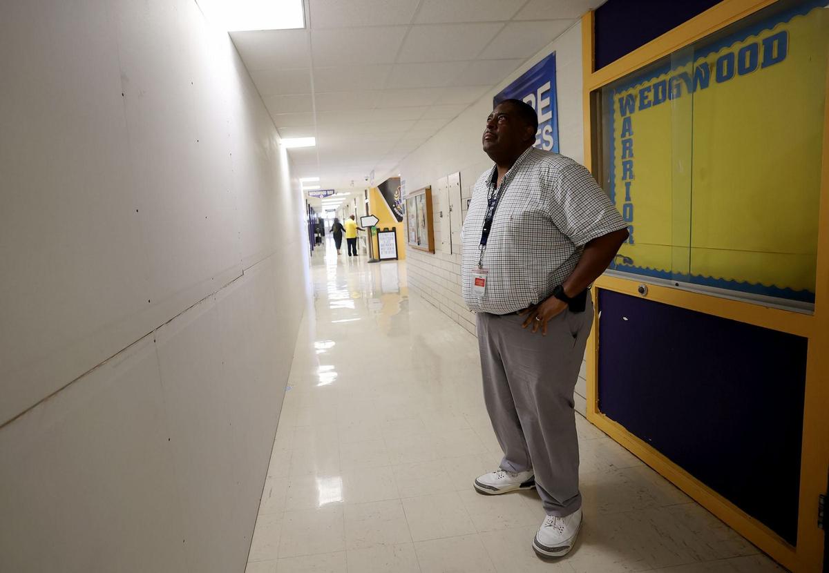 Wedgwood Middle School Principal Stanley Johnson looks at a temporary wall that shields construction from the rest of the school on Tuesday, Sept. 10, 2024. The school received bond money for renovations, including new classrooms, that are expected to be completed in February of 2026.