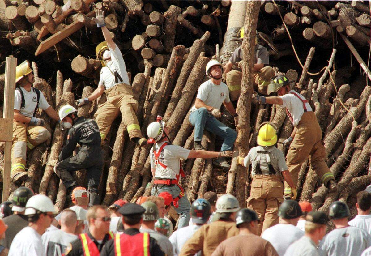 Emergency personnel dig throughout the fallen logs for the bonfire at Texas A&M in College Station that killed 12 students. Shortly before 3 a.m., the log pile shifted as dozens of students worked all night atop stacks of wood on the A&M polo fields. The top logs crashed to the ground.