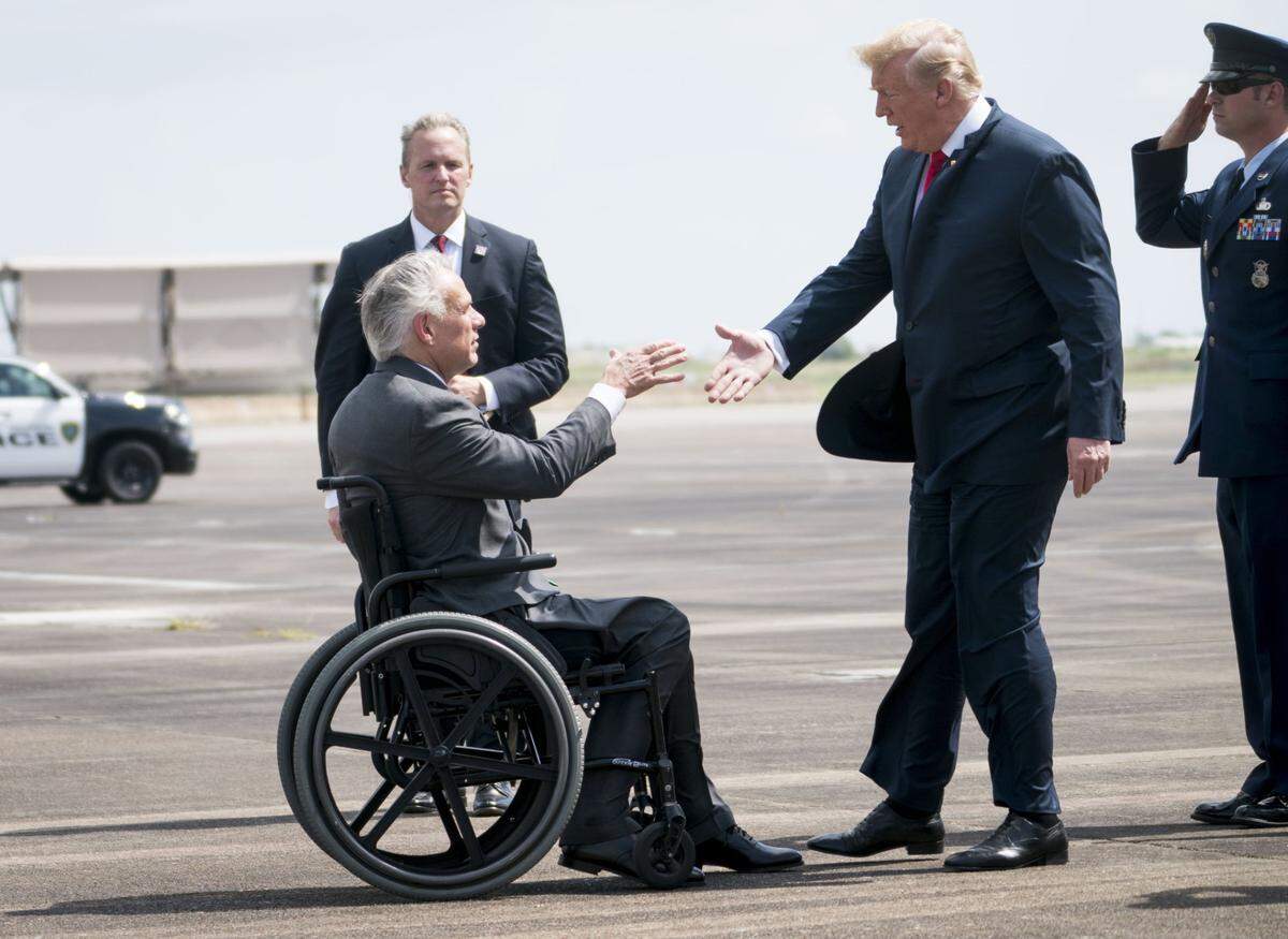 President Donald Trump is greeted by Texas Gov. Greg Abbott as he arrives to Ellington Field Joint Reserve Base in Houston, May 31, 2018. Trump is slated to meet with families of victims and first responders of the Santa Fe High School shooting, as well as with members of the Texas community on Thursday. (Doug Mills/The New York Times)