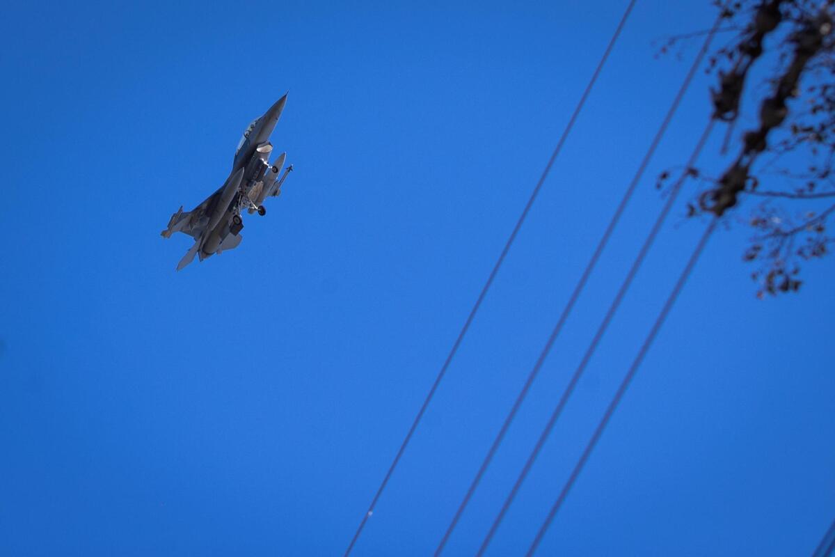 A military jet flies over homes along Caddo Trail in Lake Worth.