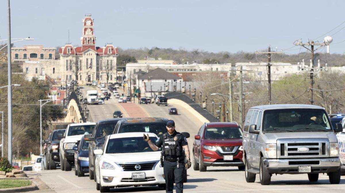 Agentes de policía dirigen el tráfico mientras los semáforos están apagados después de fuertes tormentas eléctricas en Weatherford, Texas, el viernes 3 de marzo de 2023.