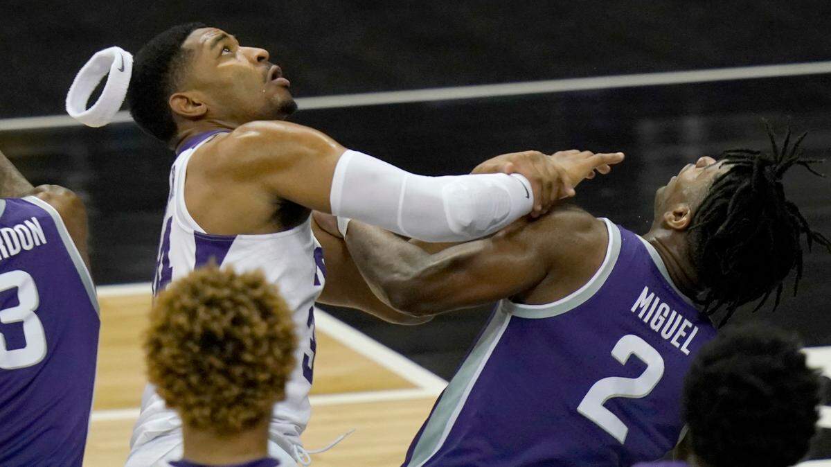 TCU forward Kevin Easley, left, loses his headband while he and Kansas State guard Selton Miguel (2) look for a rebound during the first half of Wednesday’s Big 12 tournament game in Kansas City, Mo.