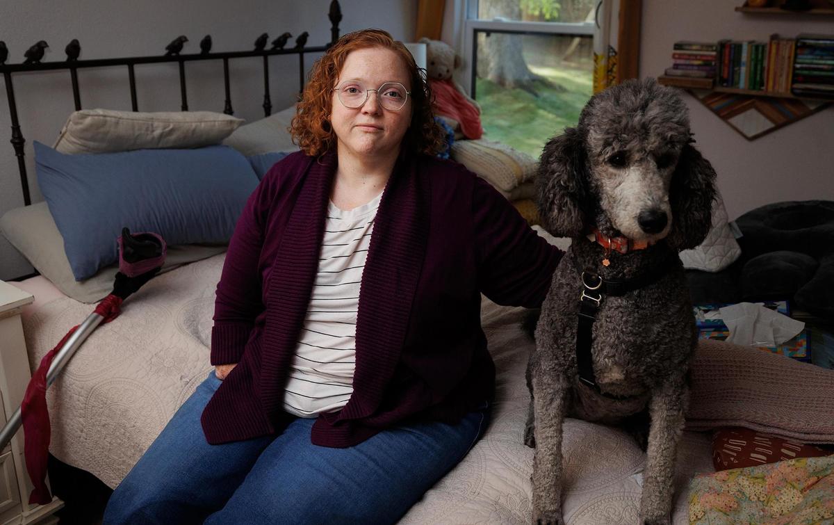 Melissa Dossey sits with her service dog Coraline, while wearing her new prosthetic legs on Wednesday, April 9, 2025, in North Richland Hills. Dossey would have had her health care severely disrupted if her insurer, Blue Cross Blue Shield, hadn’t been able to resolve the contract dispute with Southwestern Health Resources.