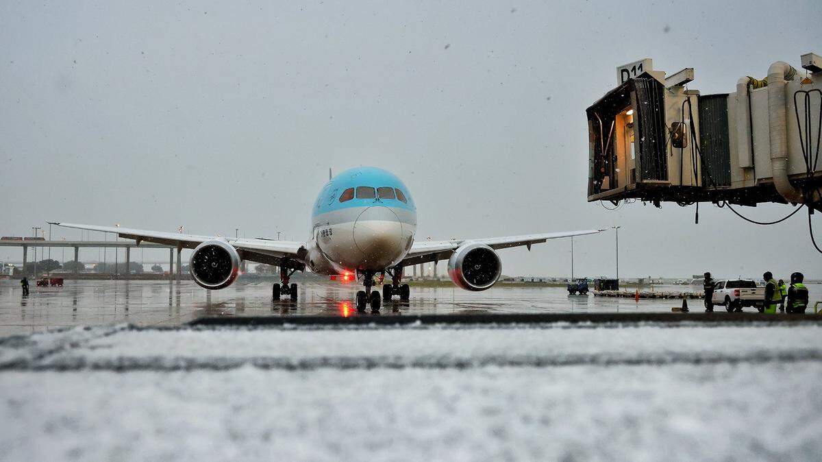 A plane sits near a gate at Dallas-Fort Worth airport early on Thursday, Jan. 9, 2025, as sleet and snow move into North Texas.