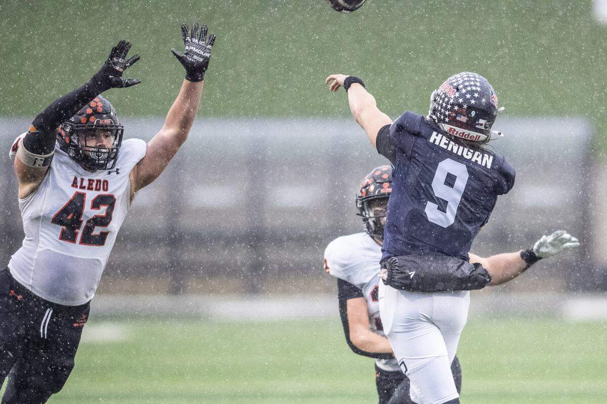 Denton Ryan quarterback Quin Henigan (9) throws a pass as Aledo’s Cooper Cyphers (42) applies pressure in a Class 5A Division 1 state quarterfinal on Saturday, Dec. 7, 2024 at Crowley ISD Multi-Purpose Stadium in Fort Worth, Texas.