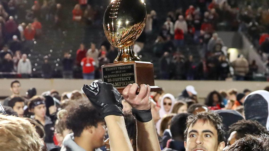 The Euless Trinity Trojans hold up their trophy after beating Arlington Martin, 56-34, Friday night, November 16, 2018 in the 6A Division I Bi-district playoff game played at Pennington Field in Bedford, TX.