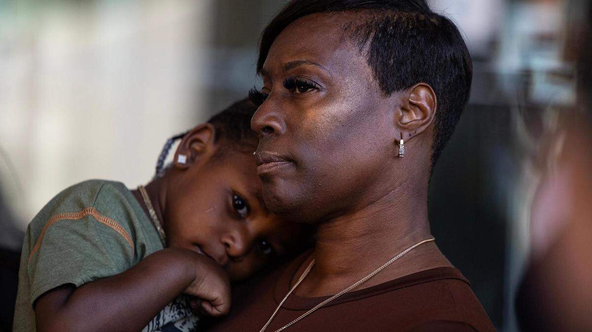 Crystal Mason carries her grandson Karter Hobbs, 3, during a news conference regarding the reversal of her conviction in an alleged illegal voting case. She had faced five years in prison.