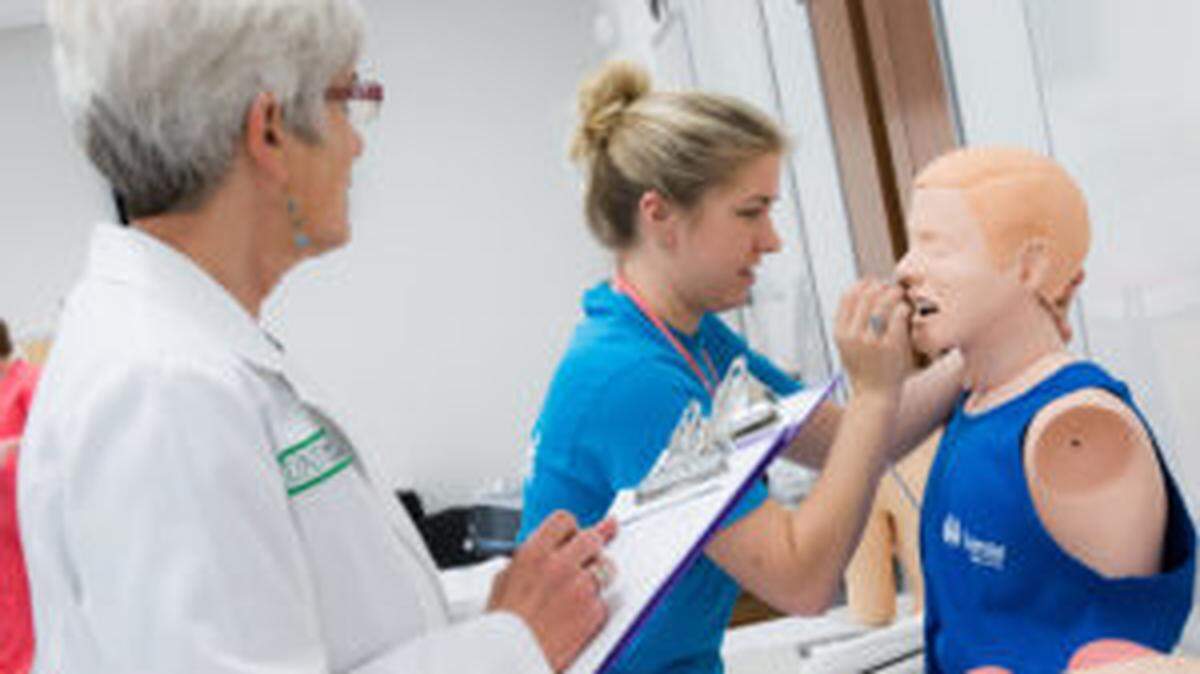 Instructor evaluating medical student during practice procedure. Texas College of Osteopathic Medicine.
