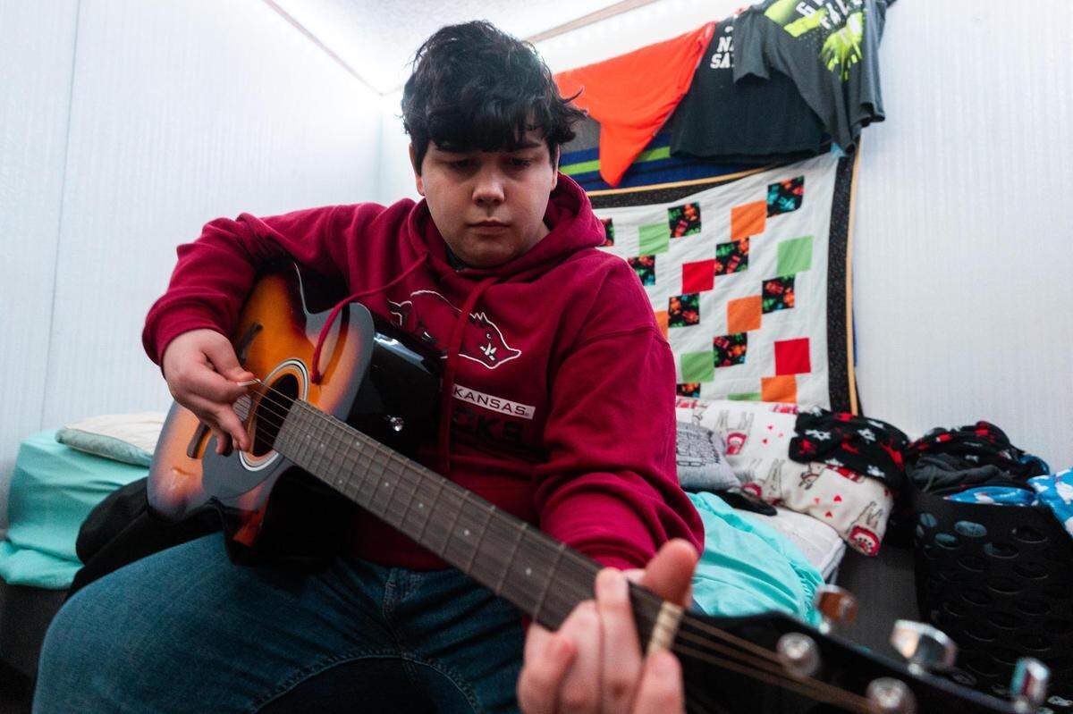 Aden Stasney, 15, who is on the autism spectrum, plays his guitar in his bedroom Feb. 22, 2022, at home in Van Alstyne. Staff at Aden’s school often deviated from the Individualized Education Plan the school created and agreed to follow, his mother said, and a pattern of escalation led to Aden facing criminal charges.