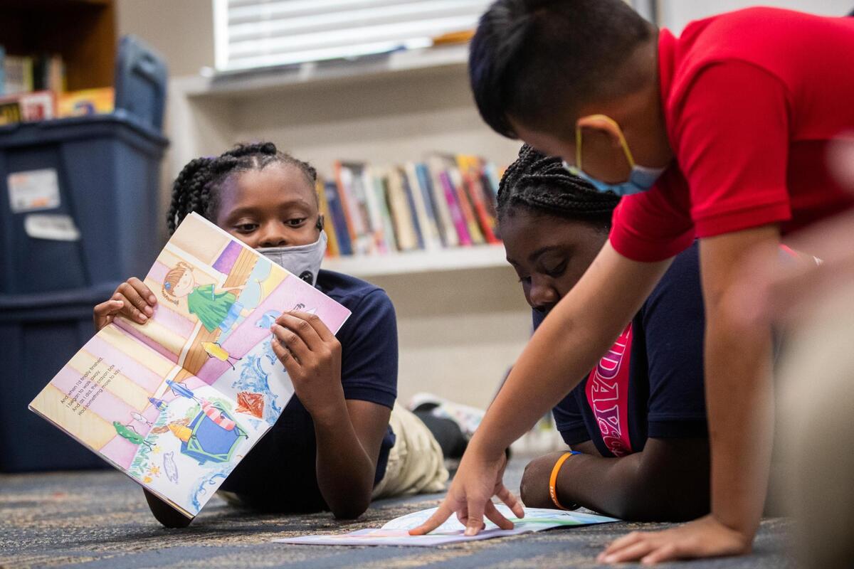 Ja’Niyah Williams, 10, left, Lyric Russell, 11, and Jonathan Calvillo, 11, discuss the book ‘The Crayon Box That Talked’ during class Thursday, Nov. 4, 2021, at Rivertree Academy in Fort Worth. The book talks about race and was funded by The Fund to Advance Racial Equity.