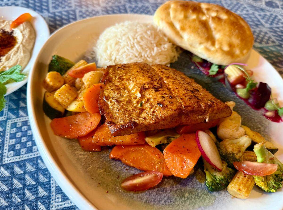 Salmon with grilled vegetables and hummus, left, at the Flying Carpet Fort Worth Turkish restaurant.