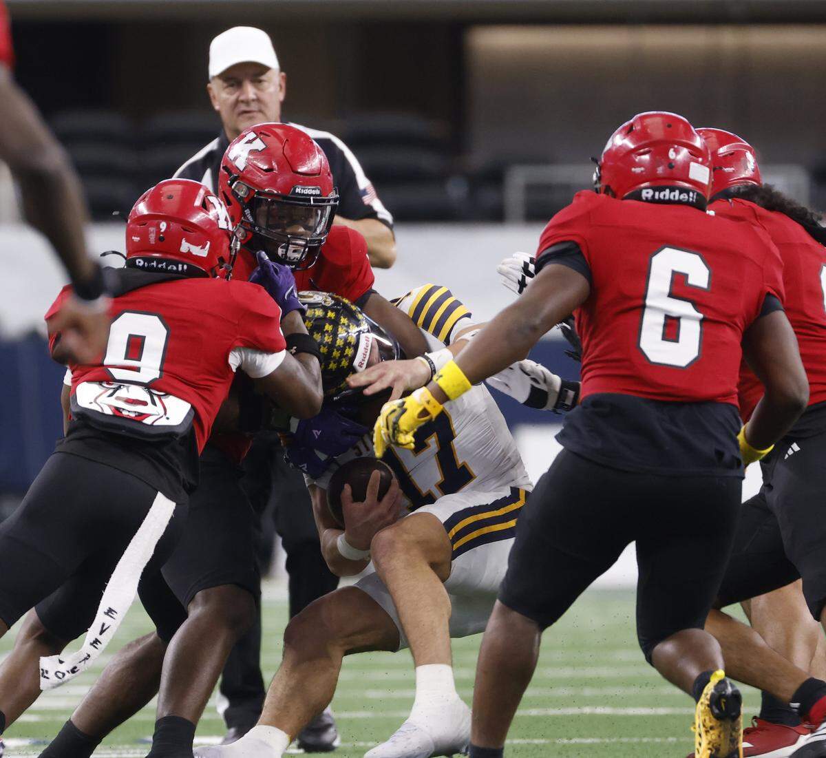 Stephenville quarterback Trot Jordan (17) is wrapped up in the backfield by the Kilgore defense during the first half of the UIL Class 4A Division I championship game on Friday Dec. 19, 2025 at AT&T Stadium in Arlington, Texas.