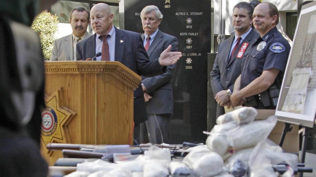San Bernardino County Sheriff Rod Hoops, at podium, speaks behind a display of weapons and drugs seized in a special joint operation conducted with the DEA against La Familia drug cartel based out of Michoacan, Mexico, at a news conference at sheriff's headquarters in San Bernardino, Calif., on Oct. 22, 2009.  This cartel has been responsible for numerous violent attacks on Mexican police officers and their families as well as other Mexican citizens, authorities say.