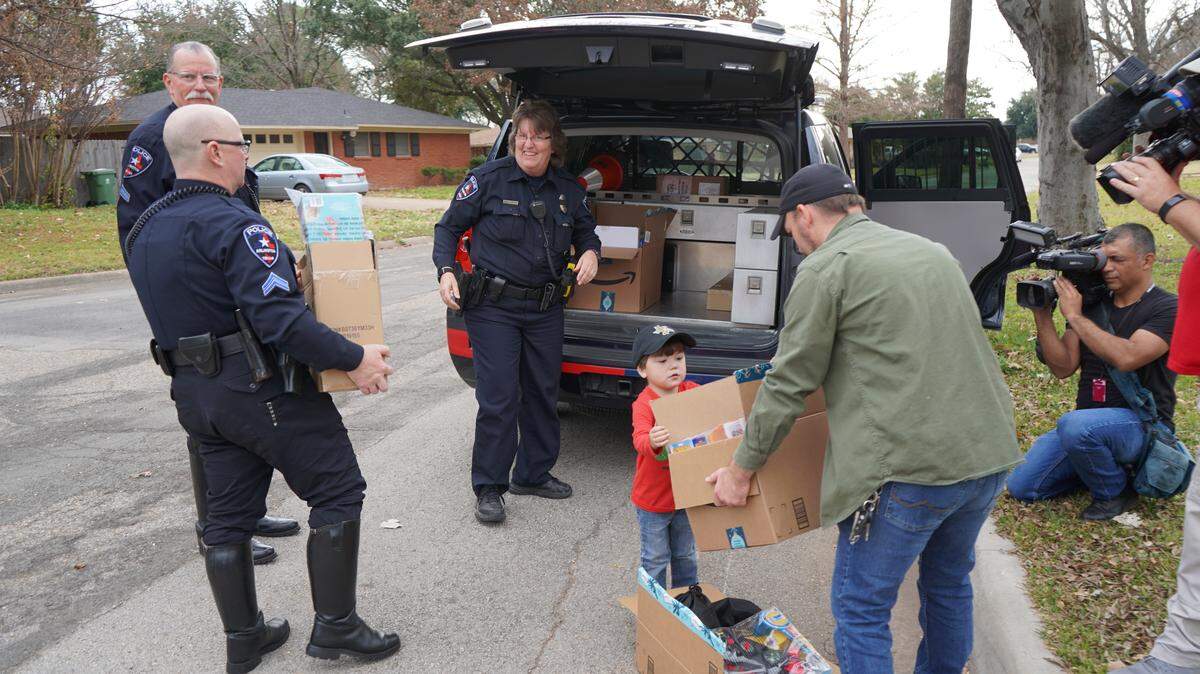 Elliott Wyche, 4, helps load toys into a police car with Arlington police and SWAT officers on Monday, Dec. 9 in Arlington. He and his family collected toys for the Arlington Police Department Santa Cops Program.