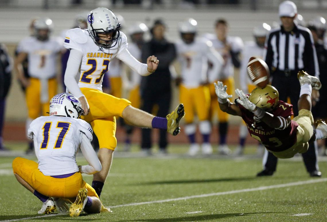 Granbury’s Logan Moore (23) kicks an extra point out of the hold by Tristan Morris (17) as Saginaw’s Sean Verdun (23) dives to attempt the block. The Granbury Pirates played the Saginaw Rough Riders in District 3-5A, division 1 high school football Friday, November 8, 2019, at Rough Rider Stadium in Saginaw, Texas.