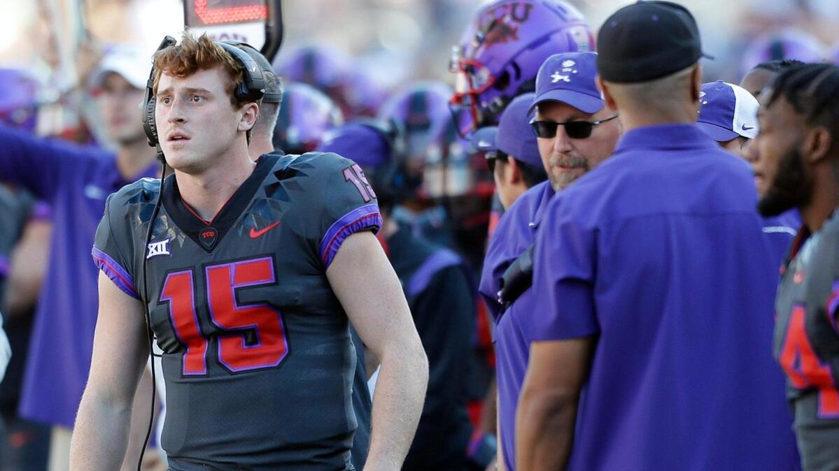 TCU quarterback Max Duggan (15) works the headphones on the sidelines against Baylor on Nov. 6. Duggan has limited mobility with a broken foot and is questionable to play Saturday against Kansas.