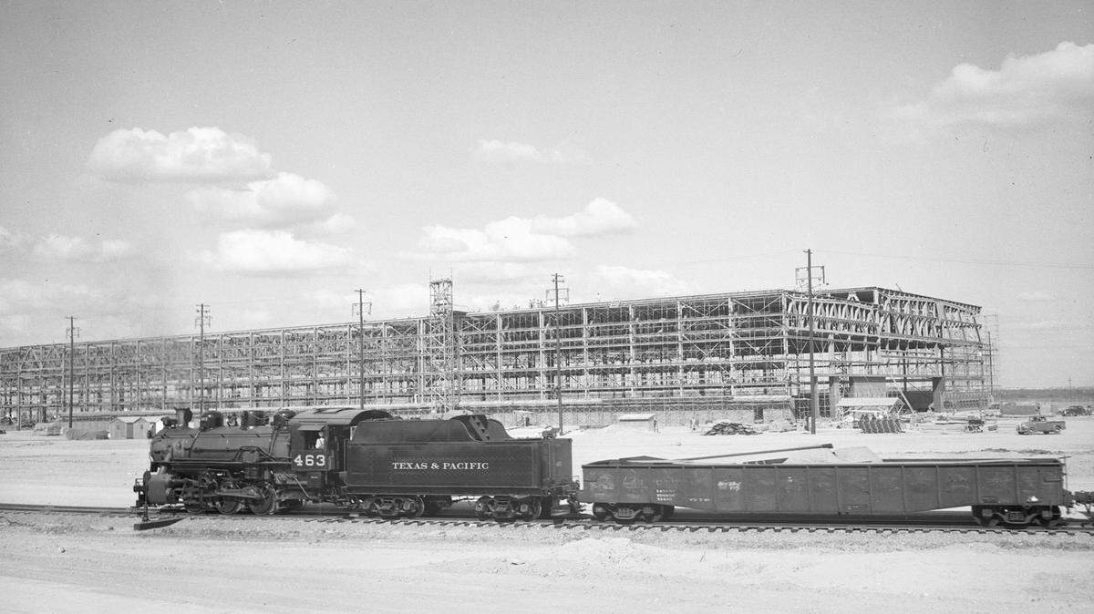A trainload of heavy steel arrives at the construction site of Fort Worth’s bomber plant in 1941. A railroad spur had to be built to supply the project.