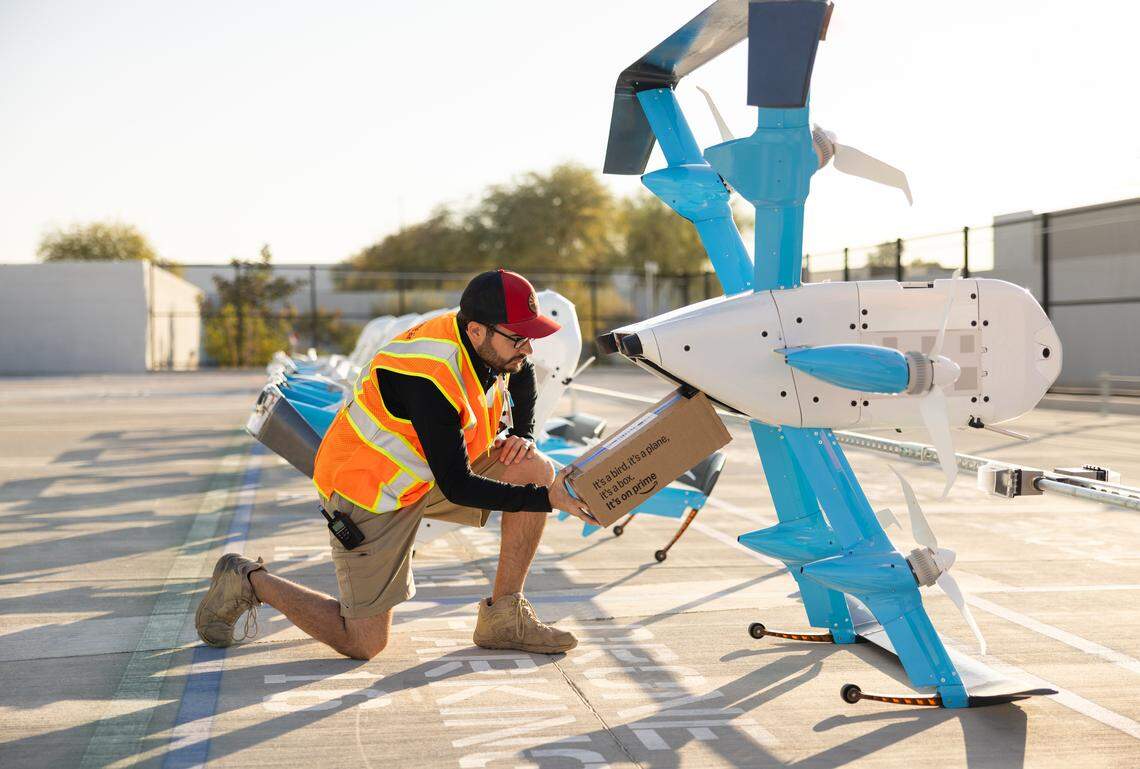 Amazon Prime is offering drone deliveries. An Amazon employee is loading the package into a drone.