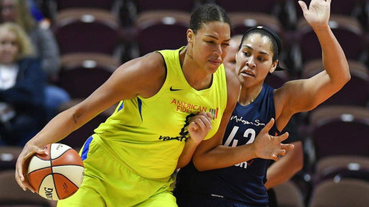 Dallas Wings’ Liz Cambage, left, won’t say officially whether she is coming back to the United States, but here is an open lobby to keep Liz Cambage from fleeing across the pond.  (AP Photo/Jessica Hill, File)