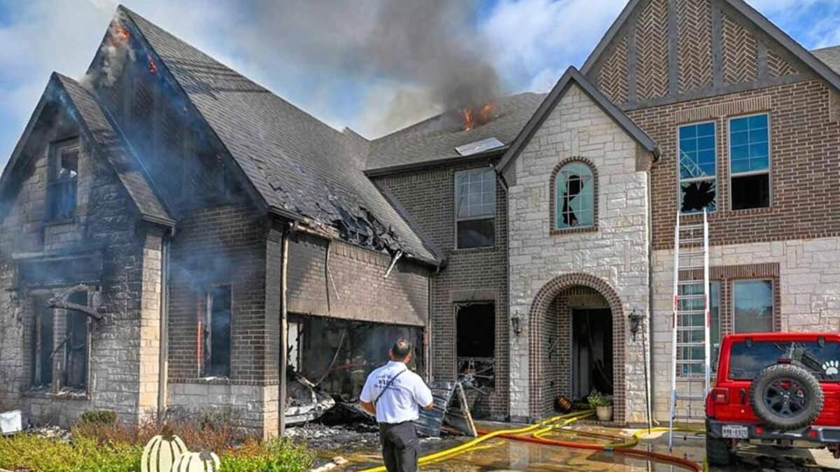 A Fort Worth Fire inspector investigates the damage at two-story house fire in the Walsh development.