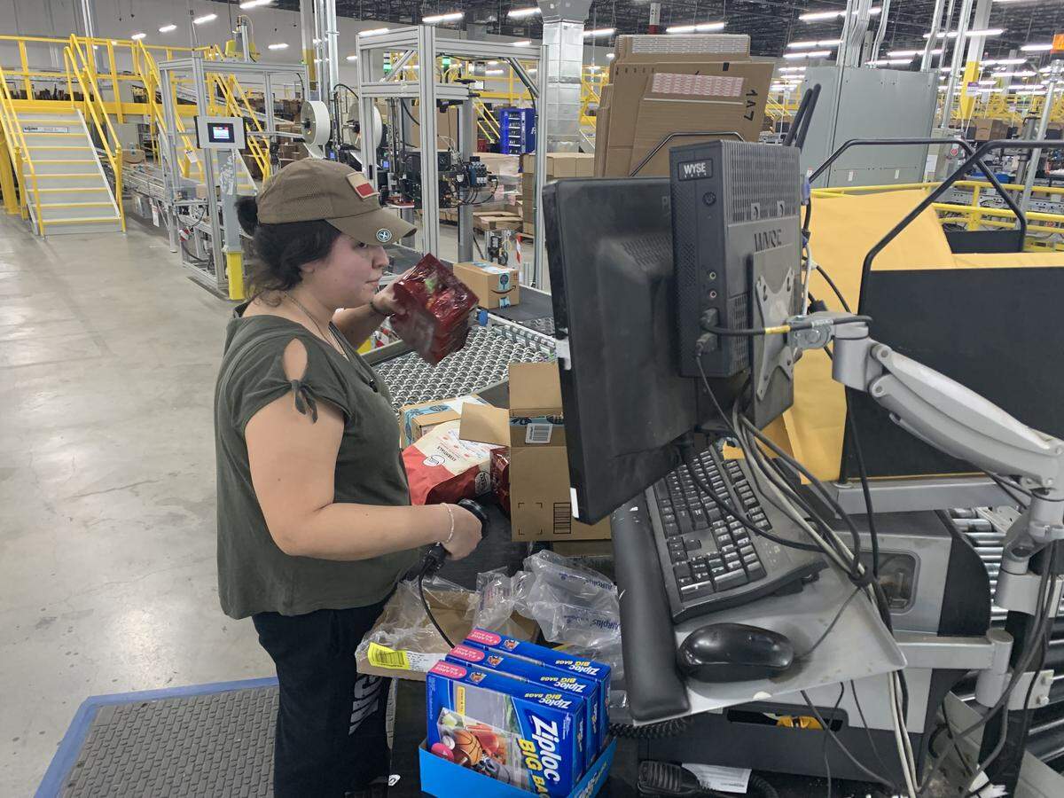 Amazon employee Michelle Scott double-checks the contents of a package at the company’s Fort Worth fulfillment center. When the computerized conveyor system detects a problem with a shipment, the package is detoured to Scott, who is considered a “problem solver.”