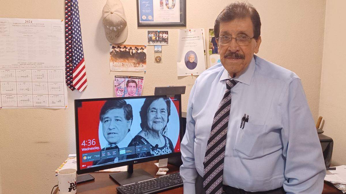 Lee Saldivar, in his Northside office, stands in front of the computer monitor with images of César Chávez and Dolores Huerta.