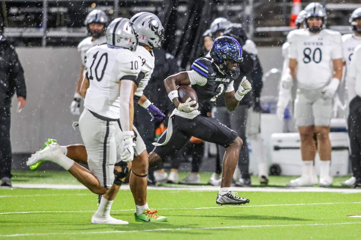 Byron Nelson’s Mahamadou Siby runs past a pair of Denton Guyer defenders in a Class 6A Division II regional semifinal Friday, Nov. 28, 2025, at Northwest ISD Stadium in Justin, Texas.