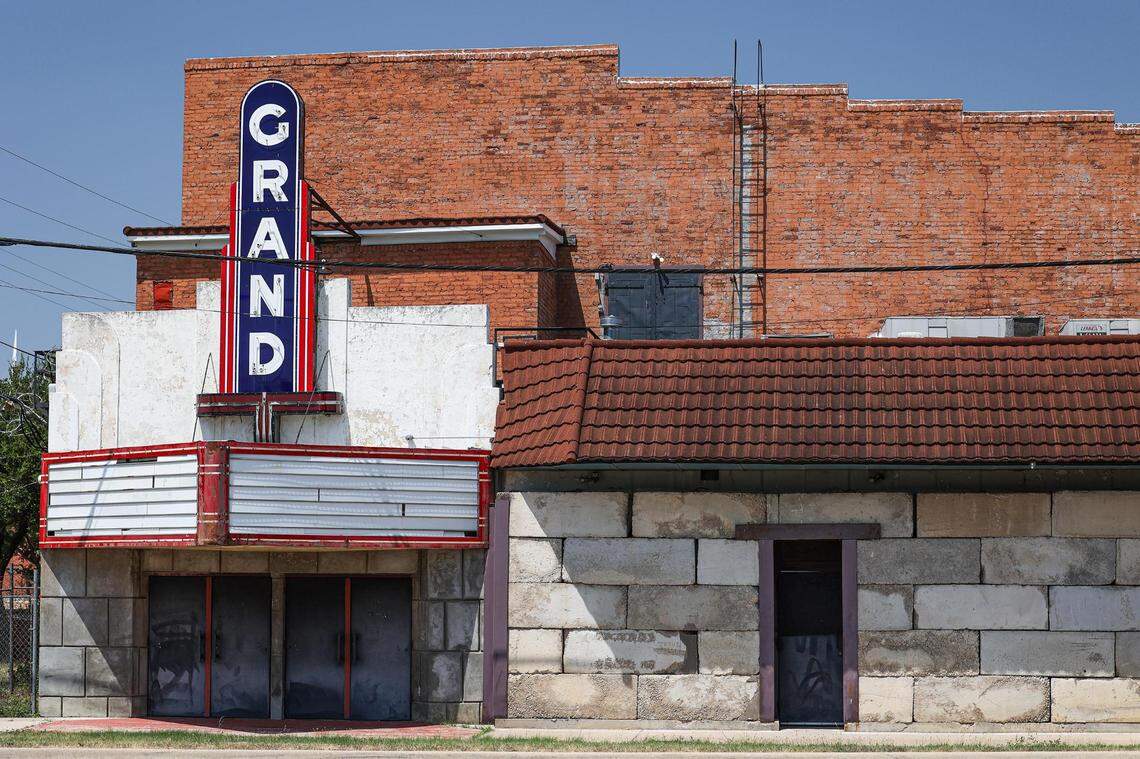 An abandoned movie theater with the marquee name "Grand" still standing.