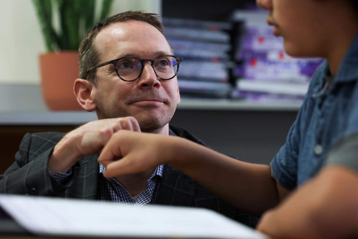 State Education Commissioner Mike Morath fist bumps Oziel Leyva while visiting his eighth grade math class at William James Middle School on Thursday.