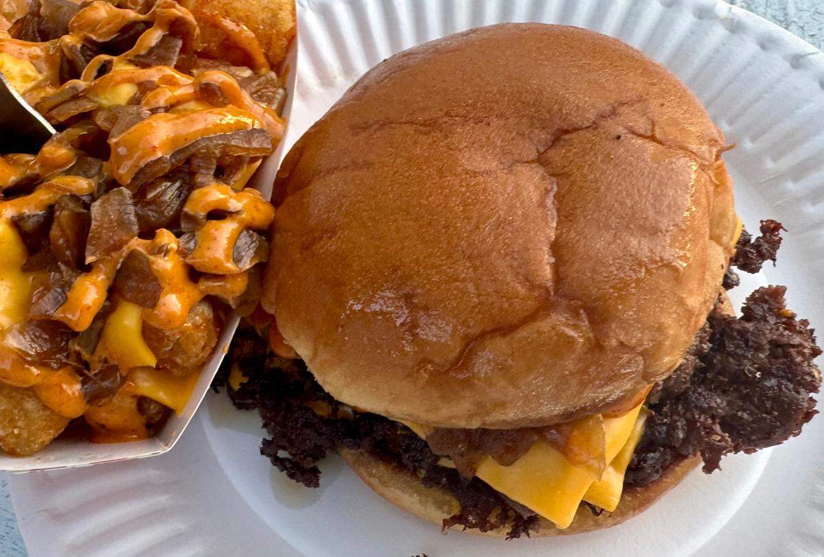 A Gustos burger with caramelized onions, pickles and sauce, with Gustos tots topped with caramelized onions and sauce at Gustos Burger Bar in Fort Worth.