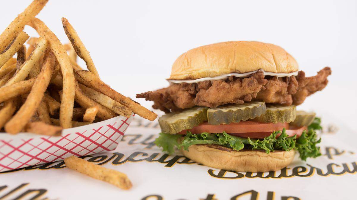 Deluxe sandwich (breaded chicken, garlic aioli, pickles, lettuce, tomato) with fries at Super Chix